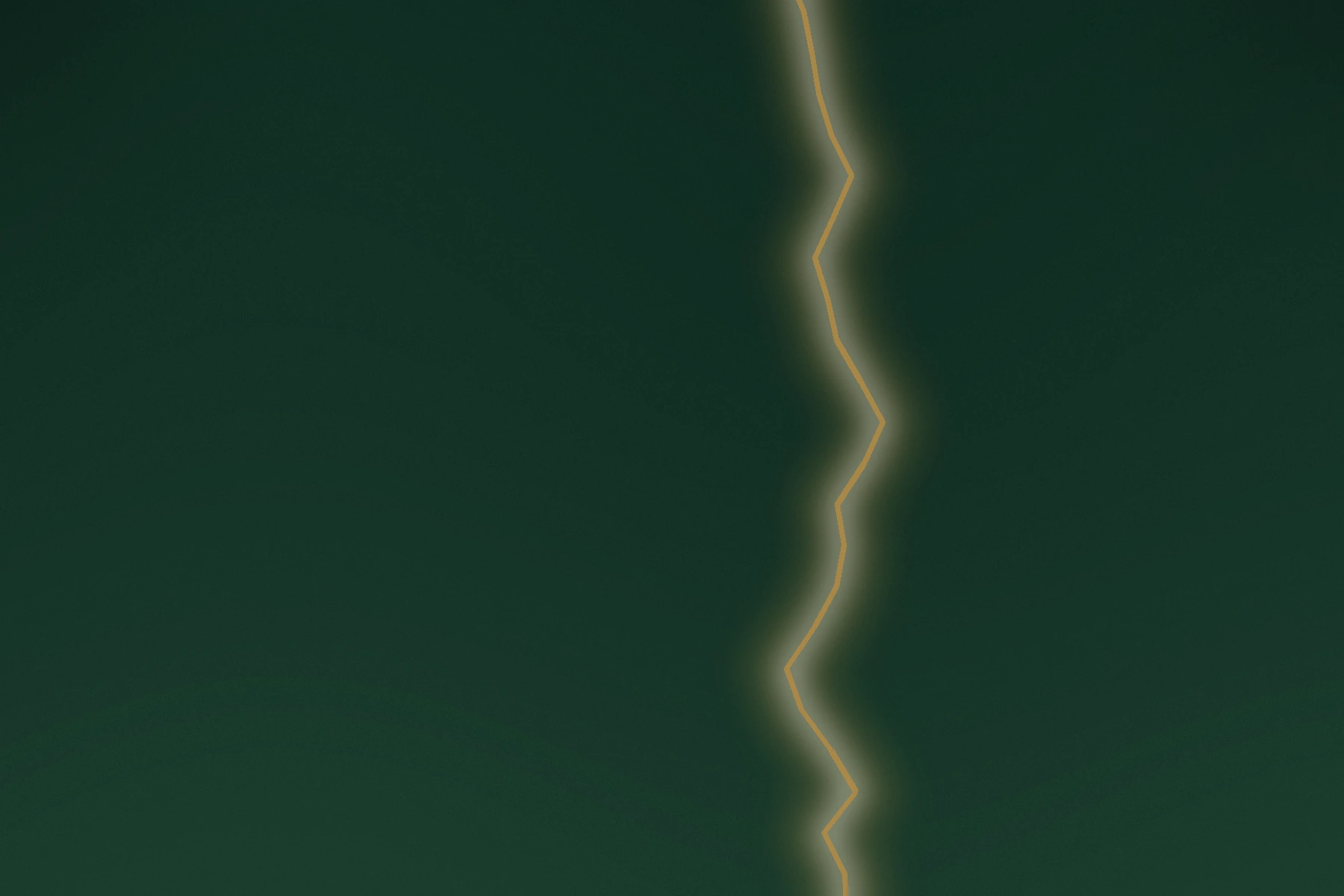 A narrow opening of warm light through a deep green field